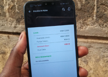 A Photo Of A User Holding A Mobile Phone Displaying Fuliza Menu.
