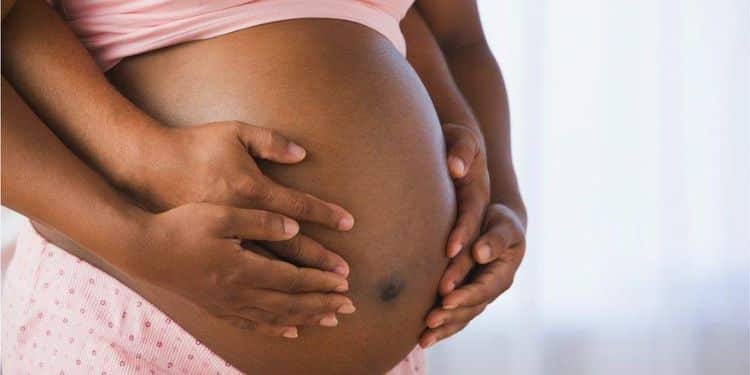 A pregnant woman holding her belly.