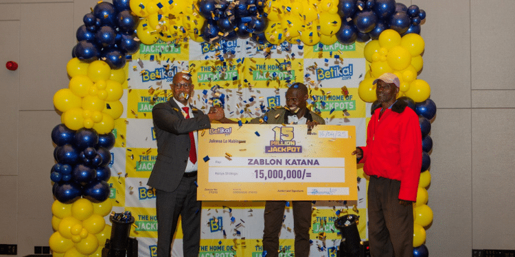 Betika Group CEO and Managing Director Kenya Mutua Mutava awards Ksh15 million to jackpot winner Zablon Katana. PHOTO/Betika X.