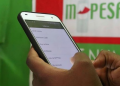 A Customer Using The Safaricom Money Transfer Mobile App. Photo/Bd