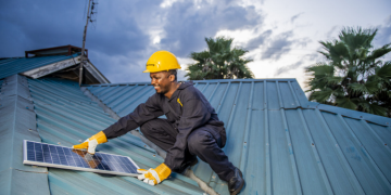 A Man Installing Solar Panel On A Roof Photo/Sun King