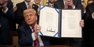 Us. President Donald Trump Displays The Genius Act After Signing It Into Law On July 19, 2025. Photo/White House. Big, Beautiful Bill