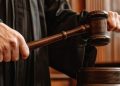 A Judge Holding A Gavel In Court.