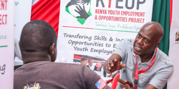 A Photo Of A Nyota Program Official Talking To A Youth During A Youth Drive.