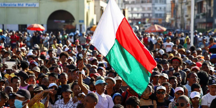 Madagascar President Dissolves Parliament Amid Protests A Protester Waves His Country'S Flag As Demonstrators Gather Outside The Town Hall On Independence Avenue During A Nationwide Youth-Led Protest Over Frequent Power Outages And Water Shortages, In Antananarivo, Madagascar, October 13, 2025. Reuters/Siphiwe Sibeko